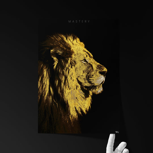 Fine art print titled ‘MASTERY’ featuring a majestic golden lion in profile view, held by a hand against a dark background.